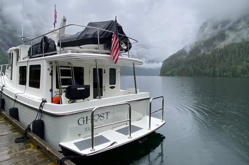 Slide: The Image of American Tug 362 (2021) docked on a serene lake with misty forested mountains. - 5