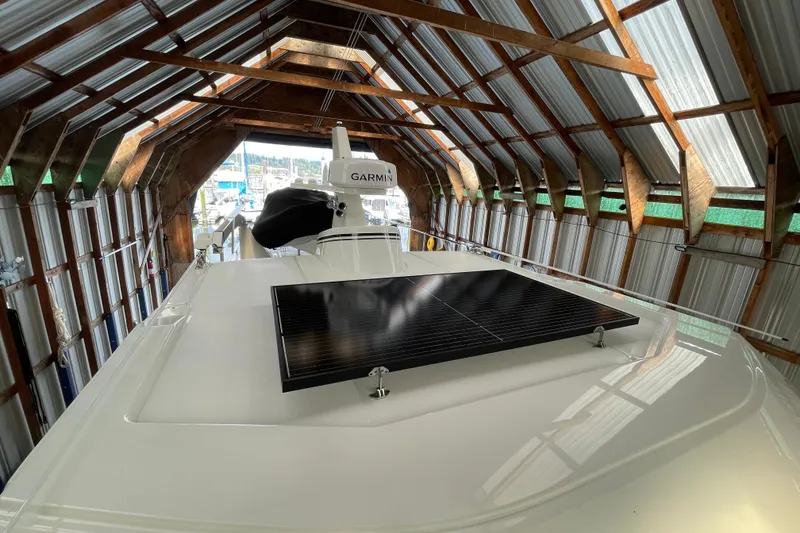 Slide: The Image of 2021 American Tug 362 in a boathouse, featuring a solar panel and Garmin equipment. - 54