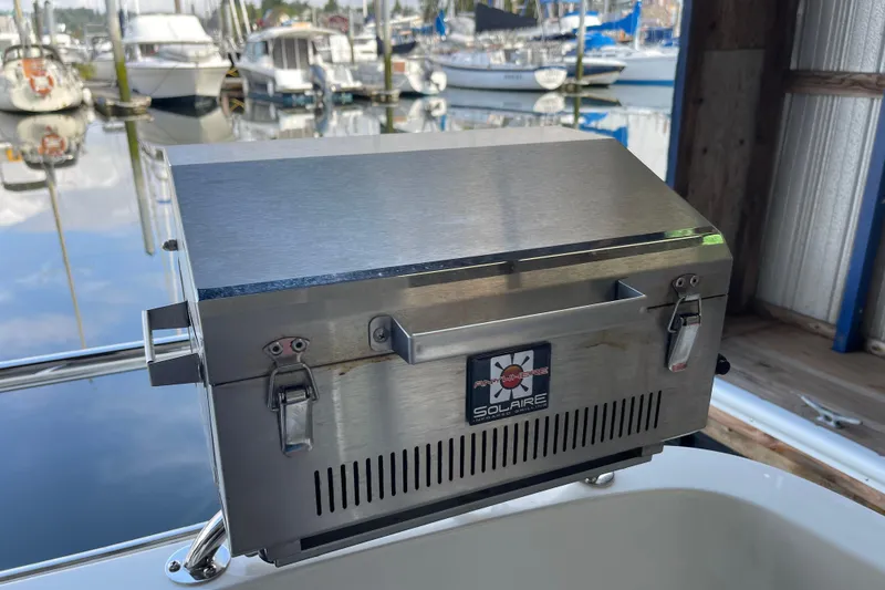 Slide: The Image of Stainless steel grill on 2021 American Tug 362, docked with boats in the background. - 59