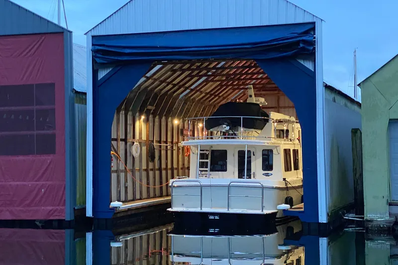 Slide: The Image of 2021 American Tug 362 docked in a covered marina slip at dusk. - 6