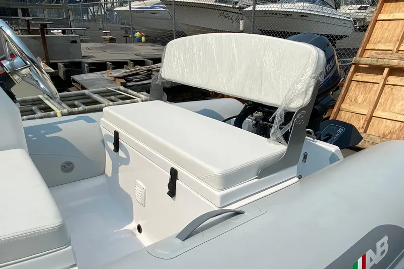 Slide: The Image of White seating area on a 2021 American Tug 362 boat, docked near other vessels. - 69