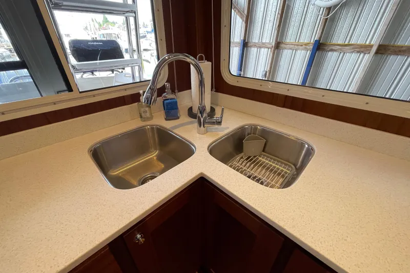 Slide: The Image of Modern kitchen sink area on 2021 American Tug 362 boat, featuring dual stainless steel sinks. - 9