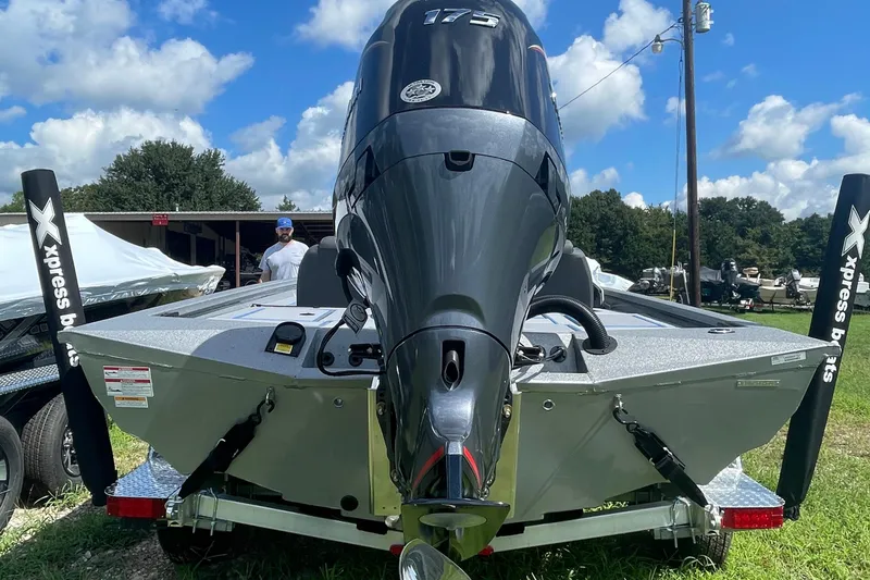 Slide: The Image of 2026 Xpress H20 Bass boat with powerful outboard motor, displayed outdoors. - 13