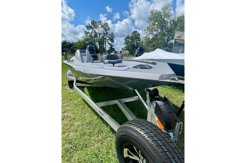 Slide: The Image of 2026 Xpress H20 Bass boat on trailer, displayed outdoors under a blue sky. - 2