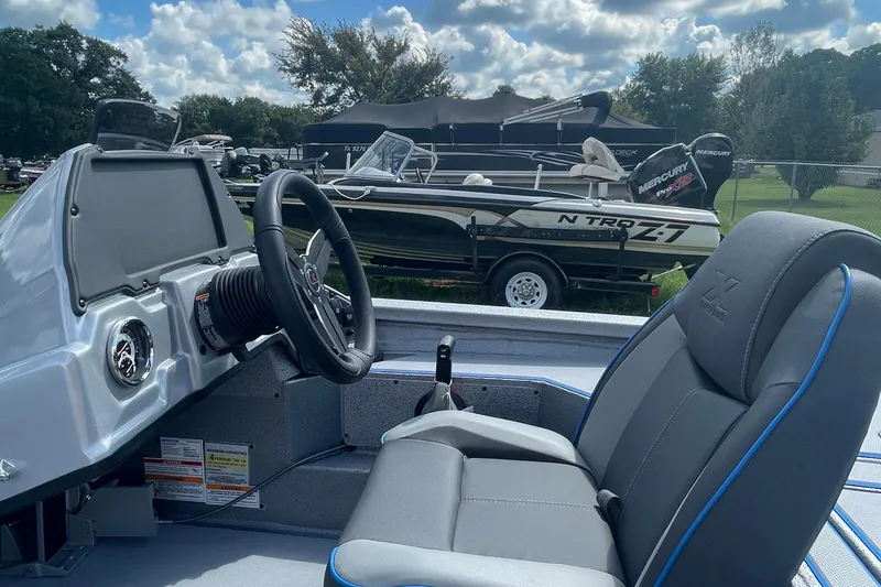 Slide: The Image of 2026 Xpress H20 Bass boat interior with steering wheel and seat, parked outdoors. - 8