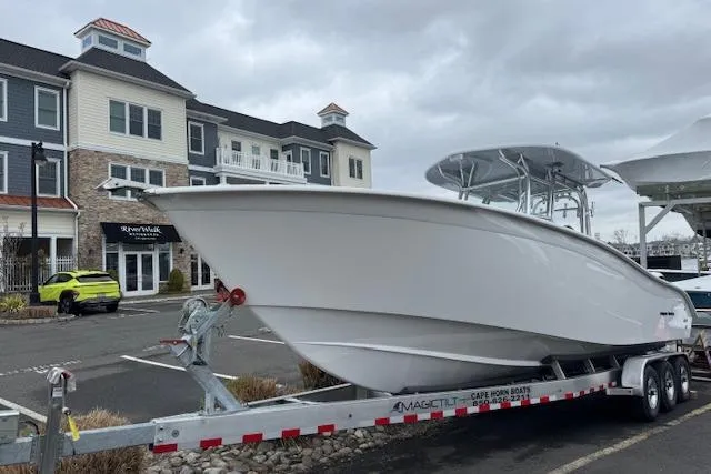 Slide: The Image of 2026 Cape Horn 31 T boat on trailer near modern buildings, overcast sky. - 9