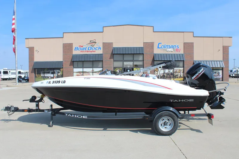 The Image of 2023 Tahoe T16 boat on trailer outside dealership, featuring sleek design and Mercury engine. - 0
