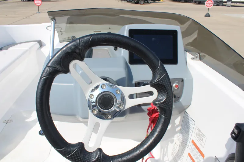 Slide: The Image of Steering wheel and dashboard of 2023 Tahoe T16 boat, featuring modern controls. - 10