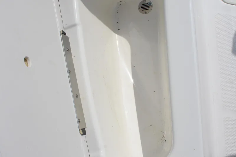 Slide: The Image of 2023 Tahoe T16 boat interior detail with drain and hinge. - 19