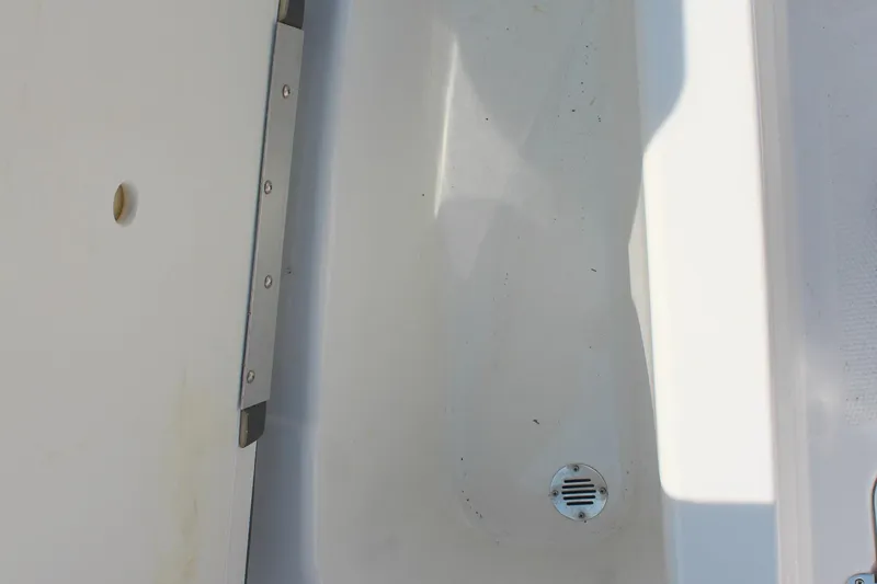 Slide: The Image of 2023 Tahoe T16 boat interior detail with drain and metal trim. - 20