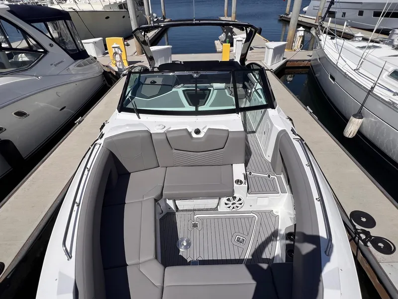 Slide: The Image of 2019 Cruisers Yachts 338 IO boat with spacious seating at a marina dock. - 18