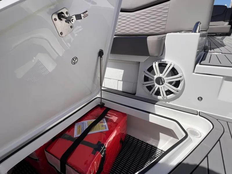 Slide: The Image of 2019 Cruisers Yachts 338 IO storage compartment with red safety equipment and speaker. - 20
