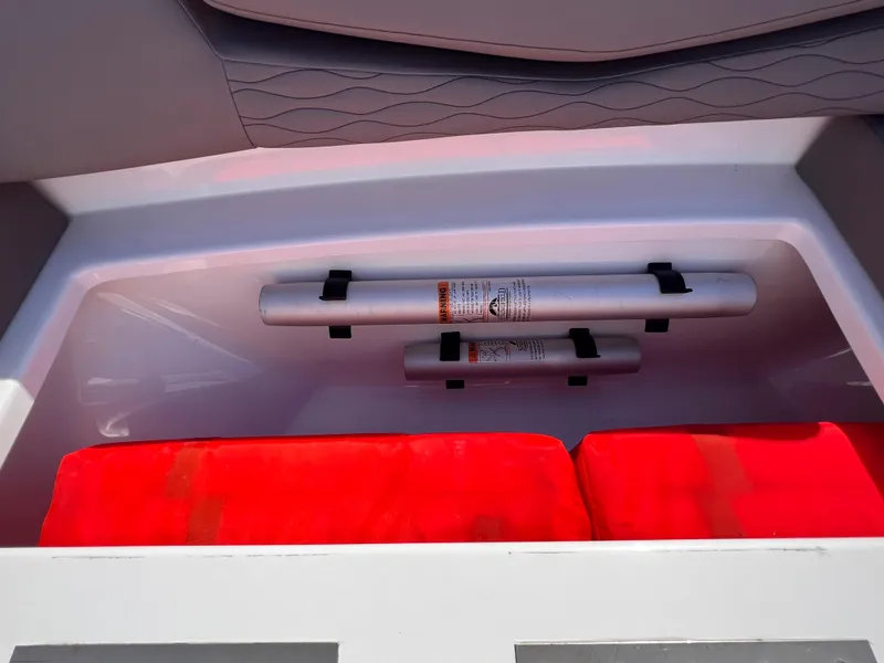 Slide: The Image of Storage compartment in 2019 Cruisers Yachts 338 IO, featuring safety equipment and red cushions. - 21