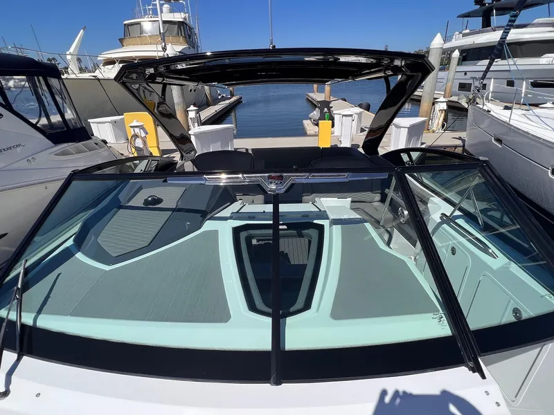 Slide: The Image of 2019 Cruisers Yachts 338 IO at marina, showcasing sleek design and spacious deck. - 24