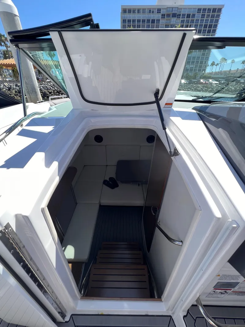 Slide: The Image of 2019 Cruisers Yachts 338 IO cabin entrance with open hatch, docked under clear blue sky. - 25