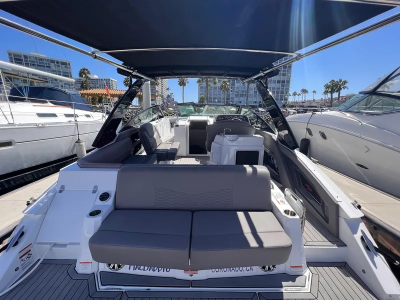 Slide: The Image of 2019 Cruisers Yachts 338 IO boat interior with seating, docked at marina under sunny skies. - 3