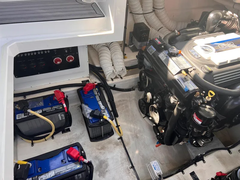 Slide: The Image of Engine compartment of 2019 Cruisers Yachts 338 IO, featuring batteries and engine components. - 40