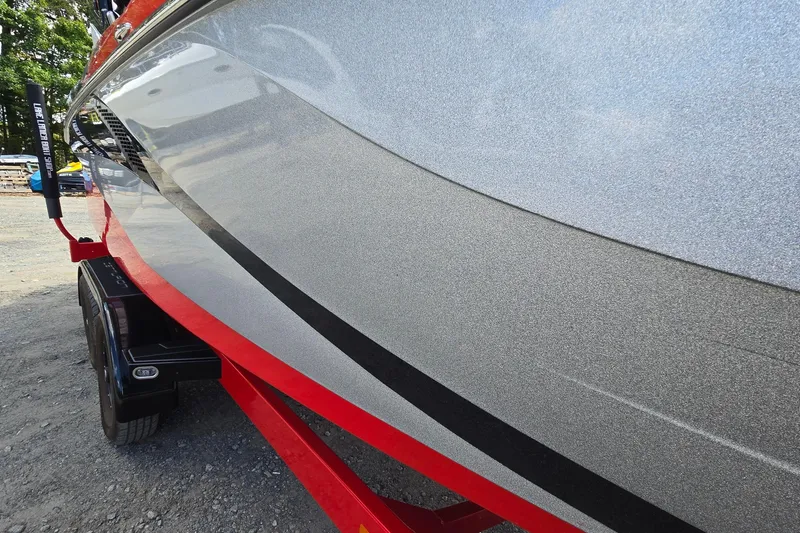 Slide: The Image of 2022 Centurion Fi23 boat on red trailer, showcasing sleek silver hull design. - 12