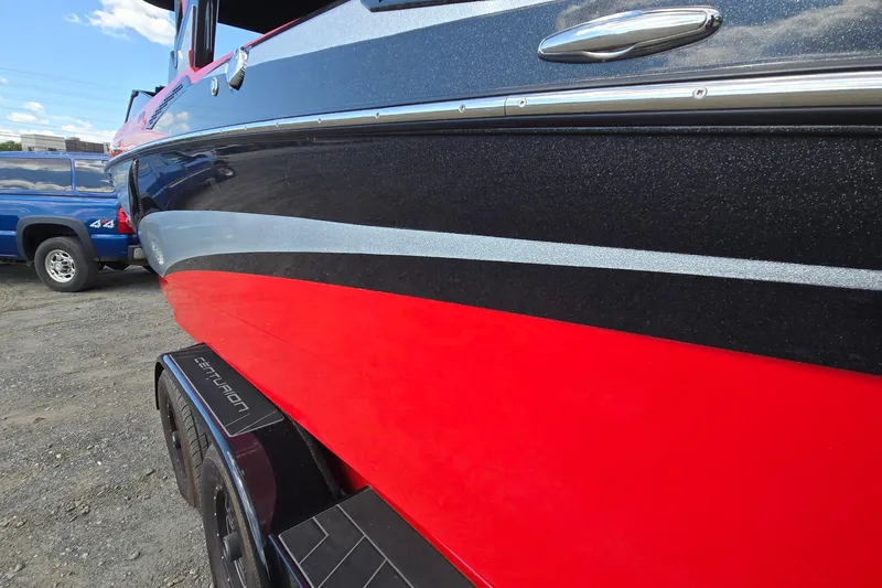 Slide: The Image of 2022 Centurion Fi23 boat with sleek red and black design on a trailer. - 13