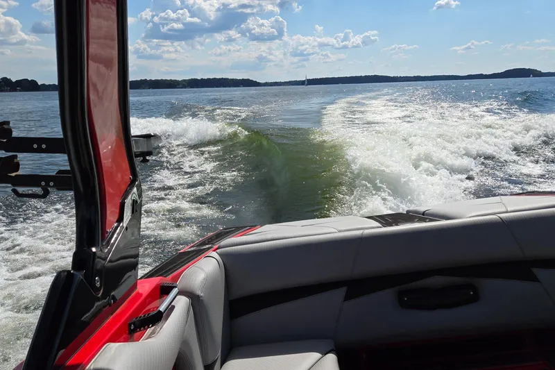 Slide: The Image of 2022 Centurion Fi23 boat creating wake on a sunny lake. - 27