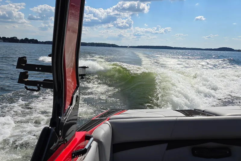 Slide: The Image of 2022 Centurion Fi23 boat creating waves on a sunny lake. - 29