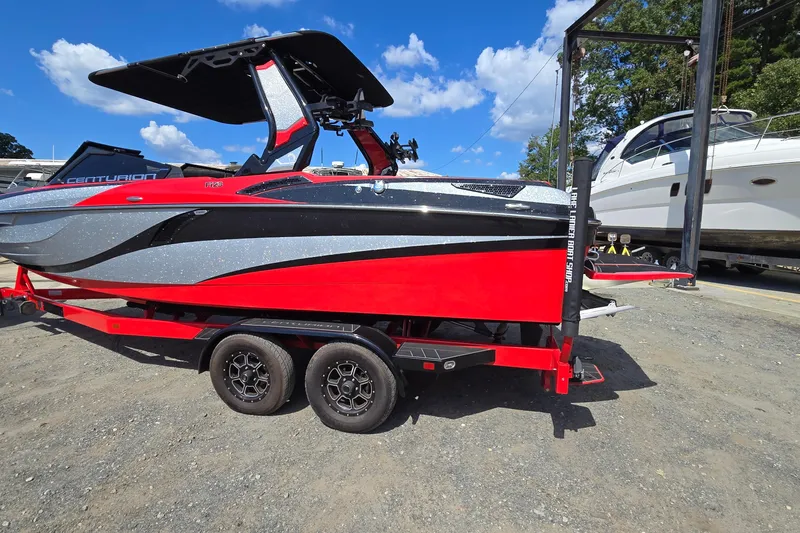 Slide: The Image of 2022 Centurion Fi23 boat in vibrant red and black, parked on a trailer. - 3