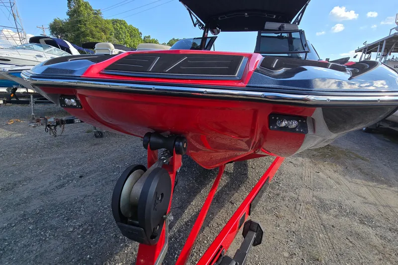 Slide: The Image of 2022 Centurion Fi23 boat on trailer, red and black design, parked outdoors. - 31