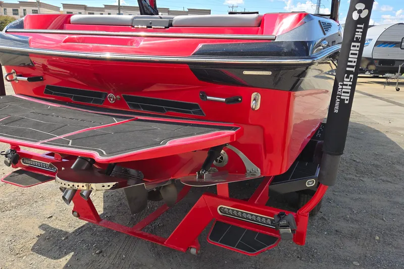 Slide: The Image of 2022 Centurion Fi23 boat rear view with vibrant red and black design. - 4