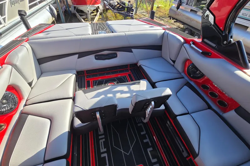 Slide: The Image of 2022 Centurion Fi23 boat interior with gray and red seating, cup holders, and speakers. - 42