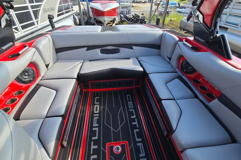 Slide: The Image of 2022 Centurion Fi23 boat interior with gray seating, red accents, and branded flooring. - 46