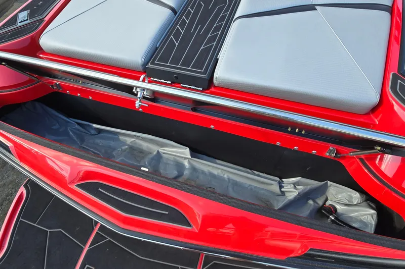 Slide: The Image of 2022 Centurion Fi23 boat storage compartment with red exterior and gray seating. - 48