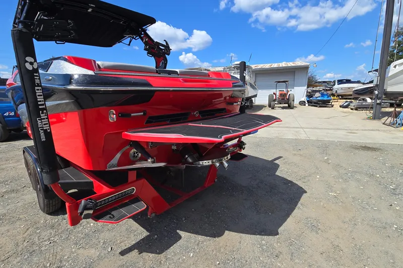 Slide: The Image of 2022 Centurion Fi23 boat in vibrant red, parked outdoors under a clear blue sky. - 5