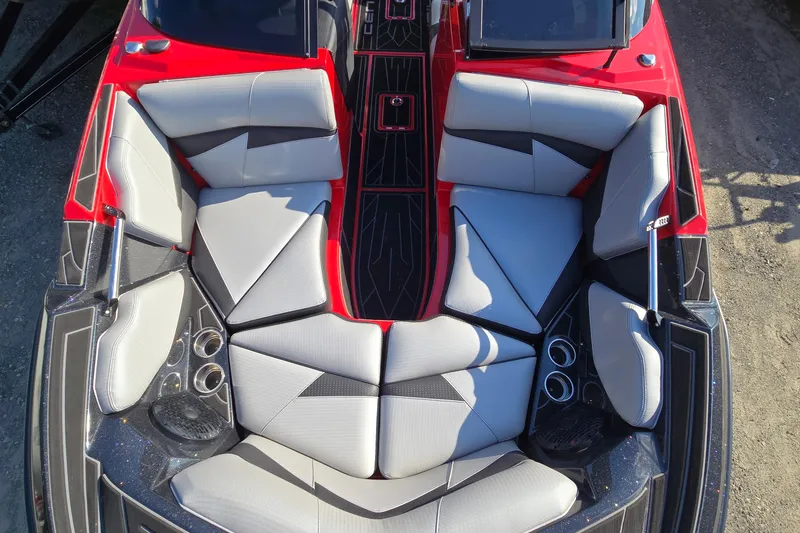Slide: The Image of 2022 Centurion Fi23 boat interior with red and gray seating, cup holders, and sleek design. - 52