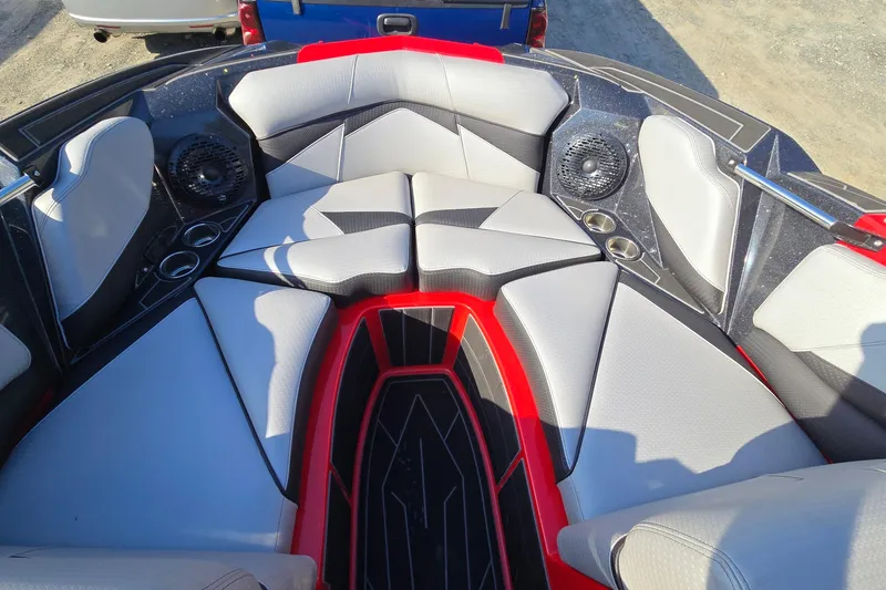 Slide: The Image of 2022 Centurion Fi23 boat interior with red and gray seating, cup holders, and speakers. - 53