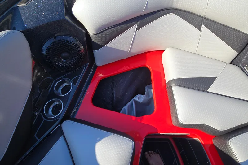 Slide: The Image of 2022 Centurion Fi23 boat interior with red accents, cup holders, and speaker system. - 56