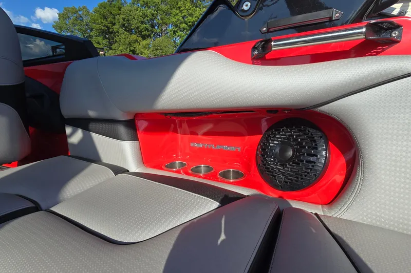 Slide: The Image of 2022 Centurion Fi23 boat interior with red accents, speaker, and cup holders. - 58