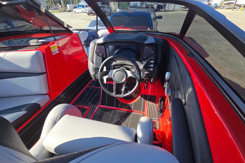 Slide: The Image of 2022 Centurion Fi23 boat interior with red and black accents, featuring a modern steering console. - 64