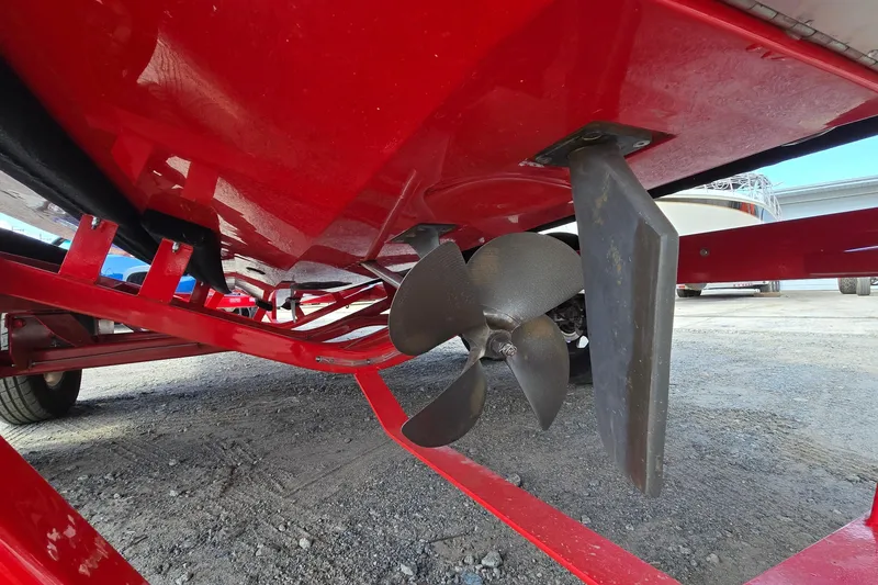Slide: The Image of 2022 Centurion Fi23 boat underside showing propeller and rudder on red trailer. - 8