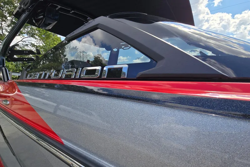 Slide: The Image of 2022 Centurion Fi23 boat with sleek design and red accents under a blue sky. - 9