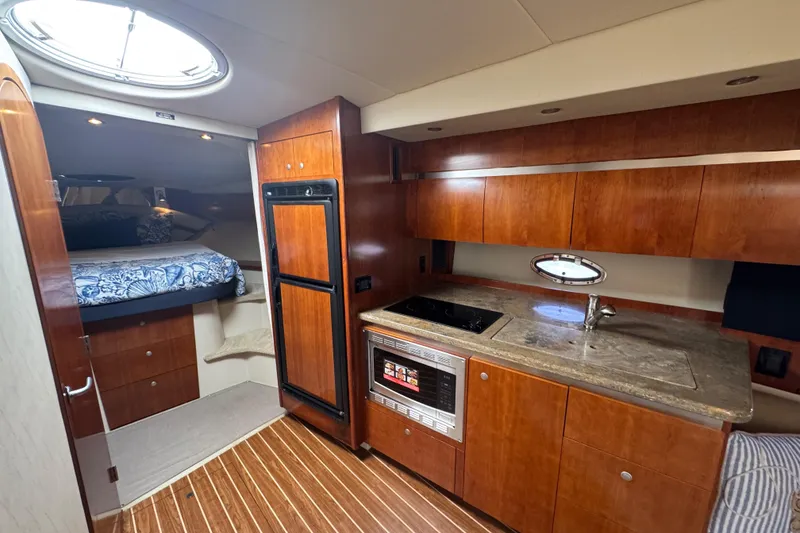 Slide: The Image of Luxurious 2008 Cruisers 420 yacht interior with kitchenette and cozy sleeping area. - 17