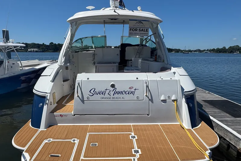 Slide: The Image of 2008 Cruisers 420 yacht for sale, docked at marina, "Sweet & Innocent" nameplate visible. - 2