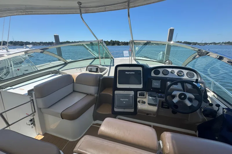 Slide: The Image of 2008 Cruisers 420 yacht helm with navigation equipment, seating, and scenic water view. - 10