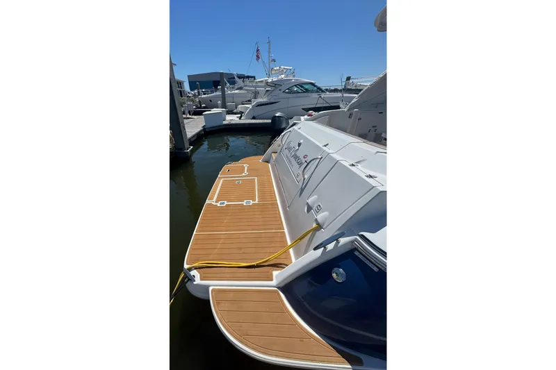 Slide: The Image of 2008 Cruisers 420 yacht docked, featuring a wooden swim platform and sleek design. - 5