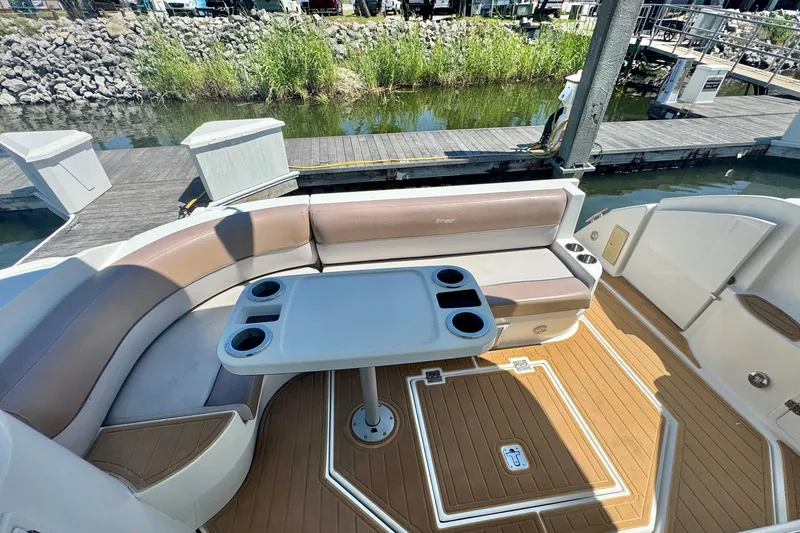 Slide: The Image of 2008 Cruisers 420 boat interior with seating and table, docked by the water. - 7