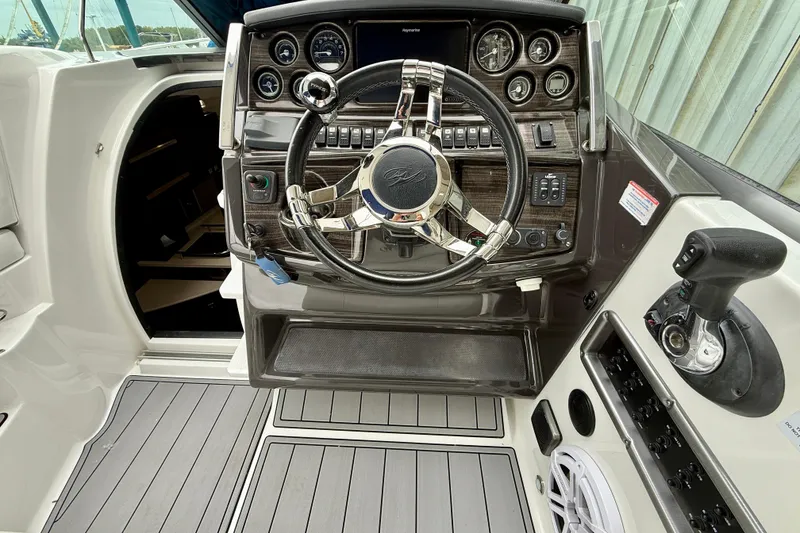 Slide: The Image of Cockpit of 2019 Monterey 295 Sport Yacht with steering wheel and control panel. - 14