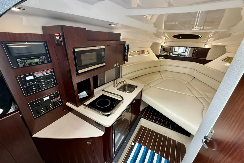 Slide: The Image of 2019 Monterey 295 Sport Yacht interior with kitchenette, seating, and modern amenities. - 16