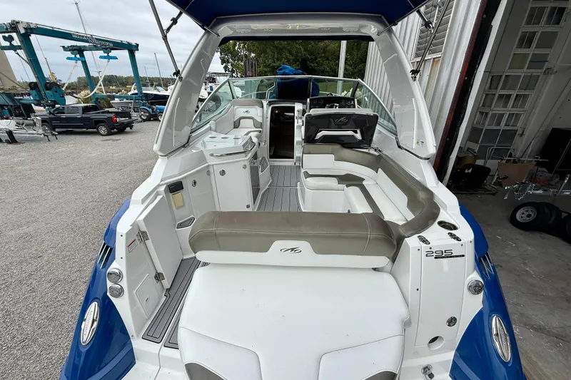 Slide: The Image of 2019 Monterey 295 Sport Yacht interior with seating and helm, docked at a marina. - 7