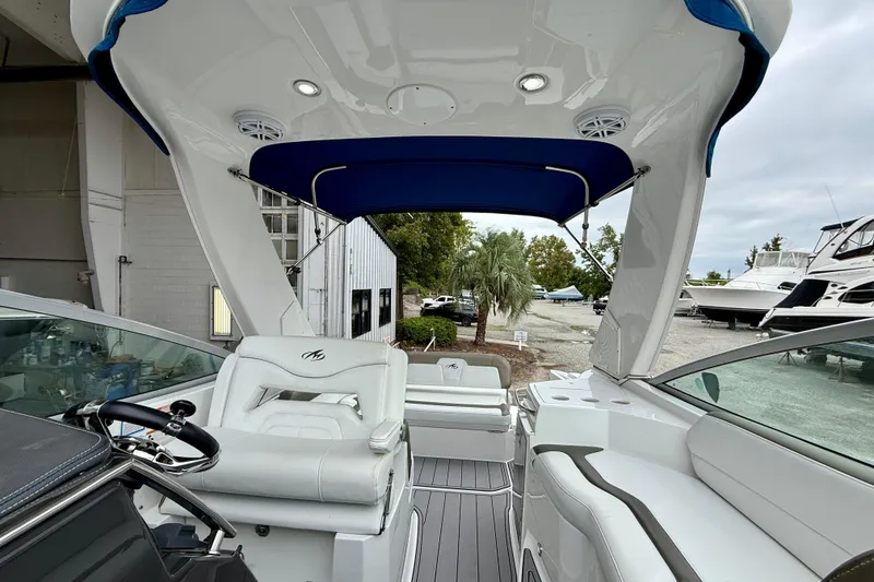 Slide: The Image of 2019 Monterey 295 Sport Yacht interior with blue canopy and white seating. - 8