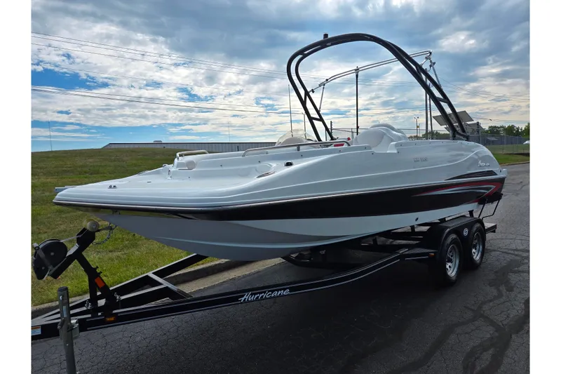 Slide: The Image of 2020 Hurricane SunDeck Sport 202 IO boat on trailer under cloudy sky. - 5