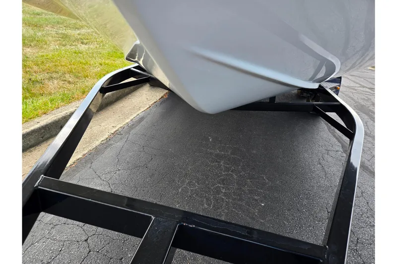 Slide: The Image of 2020 Hurricane SunDeck Sport 202 IO boat on a black trailer, parked on asphalt. - 7